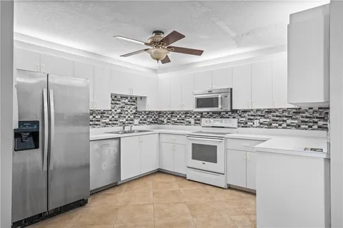 a kitchen with stainless steel appliances white cabinets and a refrigerator