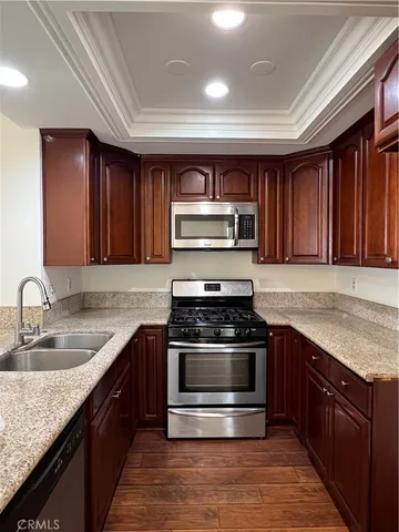 a kitchen with stainless steel appliances granite countertop a stove a sink and a microwave