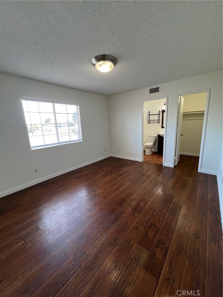 12235 Pine Street, Unit 18 Norwalk, CA 90650 - Photo 7 of 18 an empty room with wooden floor and windows