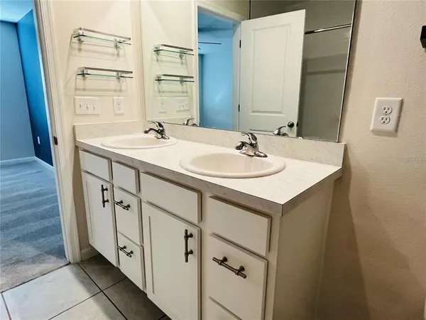 a bathroom with a double vanity sink and mirror