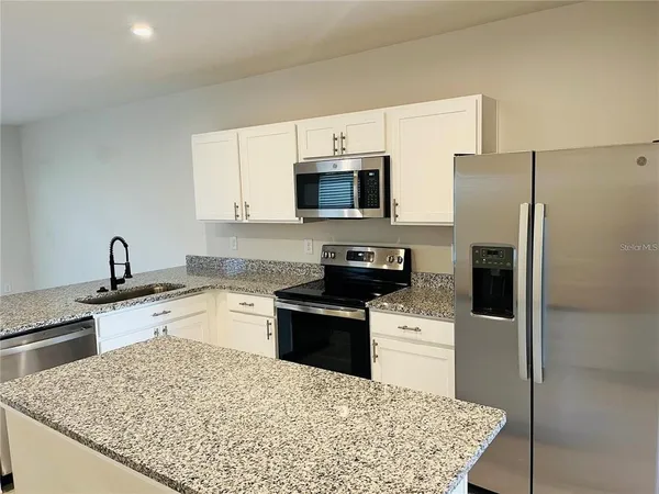 a kitchen with a sink stove and refrigerator