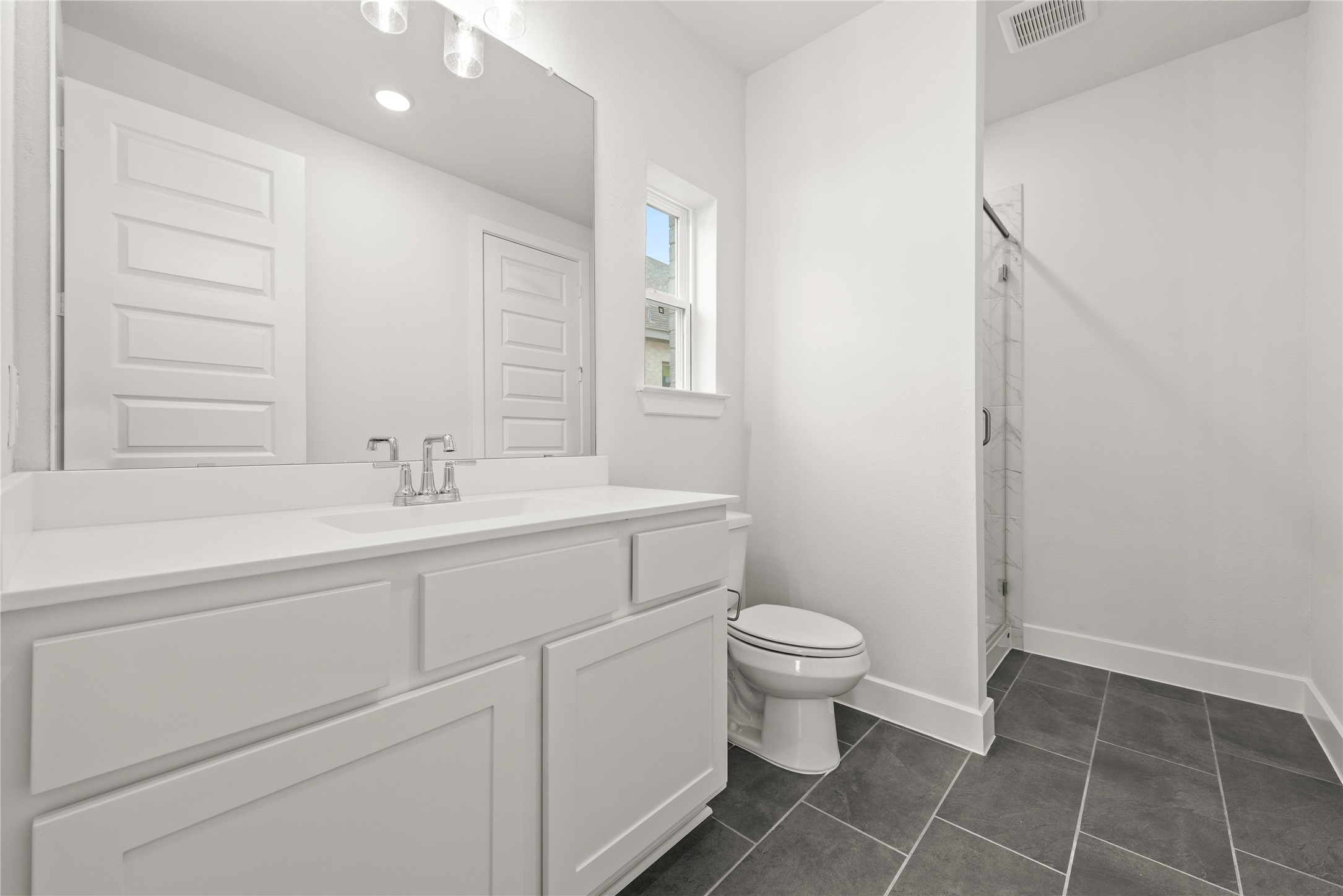 18917 Moonriver Street Conroe, TX 77302 - Photo 16 of 28 a bathroom with a sink a toilet and a mirror
