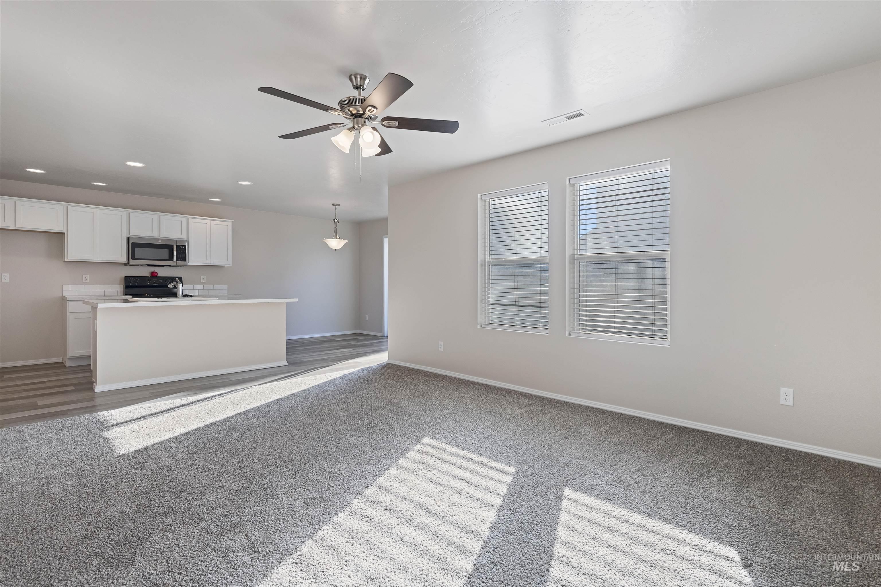 13559 Cocoa Beach Way Caldwell, ID 83607 - Photo 13 of 28 Unfurnished living room with a ceiling fan, recessed lighting, and light carpet