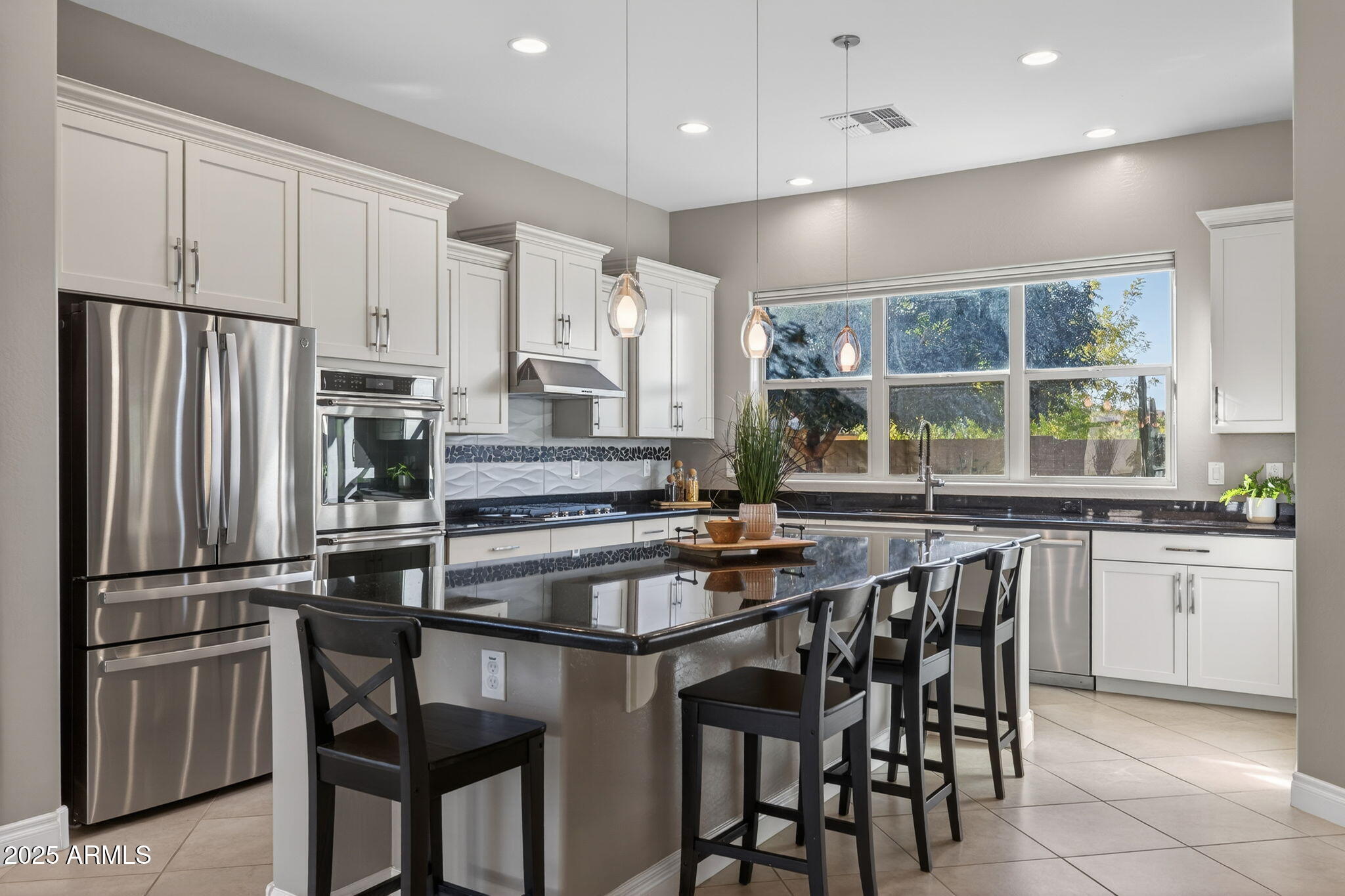 5236 South Excimer Mesa, AZ 85212 - Photo 4 of 85 a kitchen with stainless steel appliances granite countertop a stove a sink a microwave a refrigerator and white cabinets with wooden floor