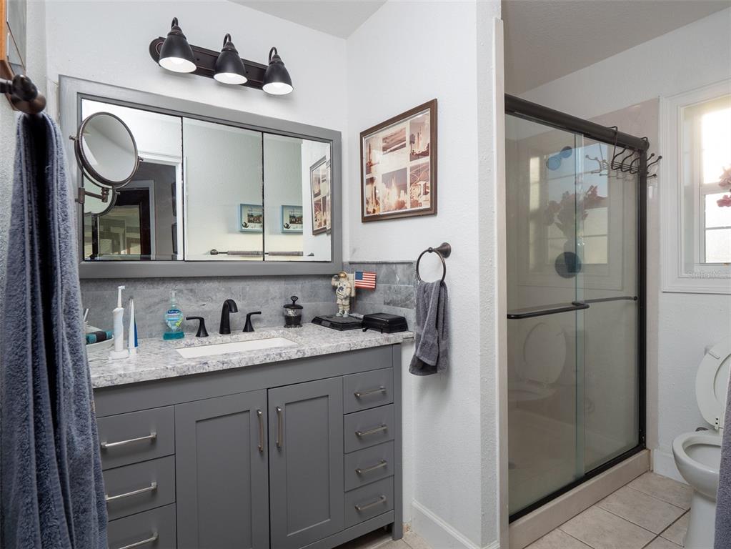 5028 West Anthony Road Ocala, FL 34475 - Photo 14 of 31 a bathroom with a granite countertop sink toilet and shower