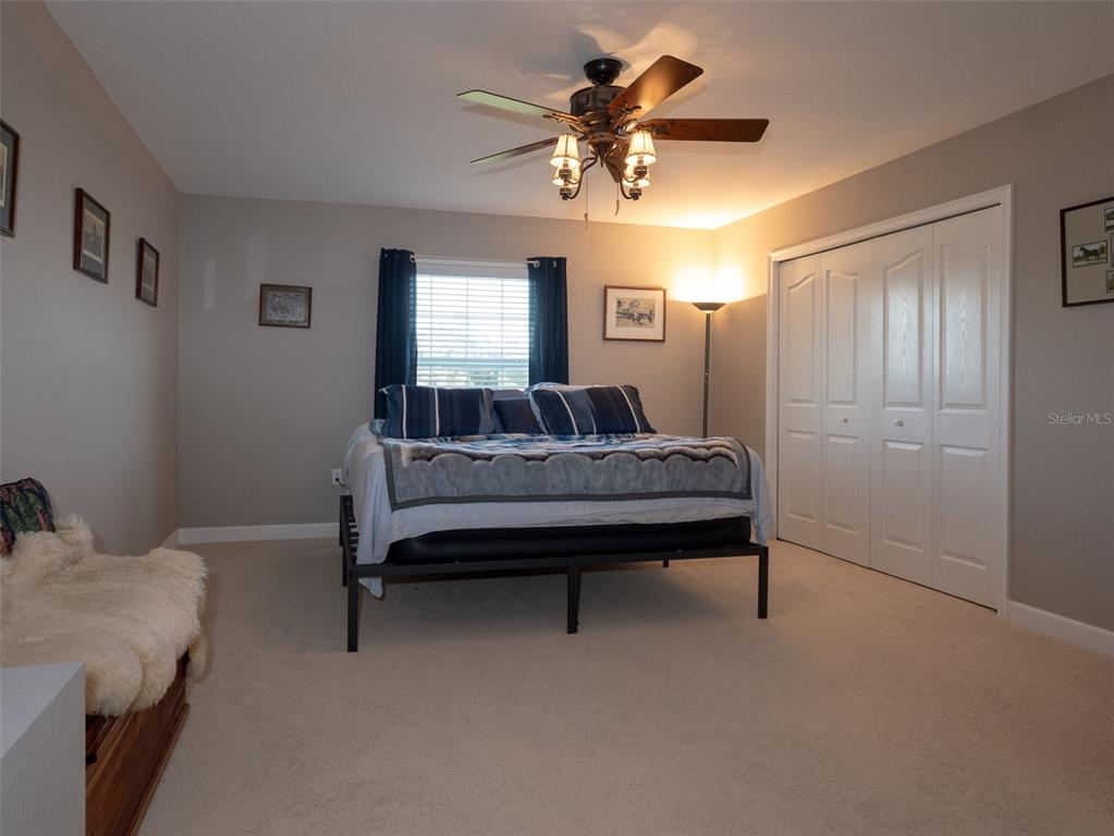 5028 West Anthony Road Ocala, FL 34475 - Photo 15 of 31 a bedroom with a bed and a chandelier