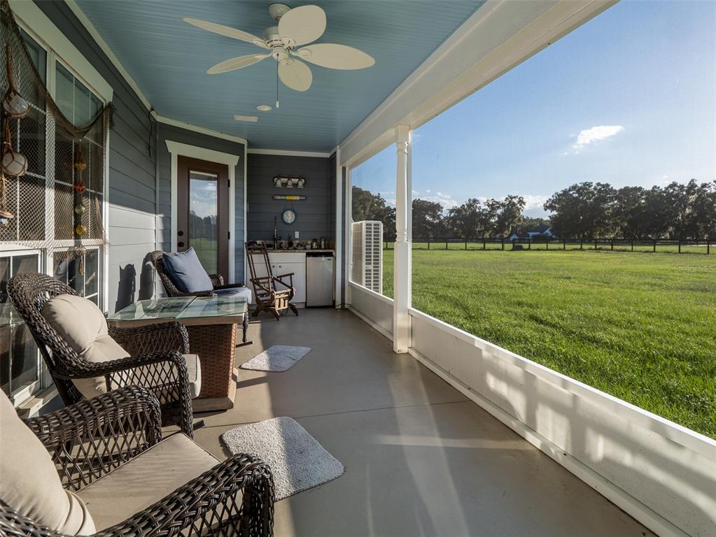 5028 West Anthony Road Ocala, FL 34475 - Photo 19 of 31 a view of a patio with couches chairs potted plants and a big yard