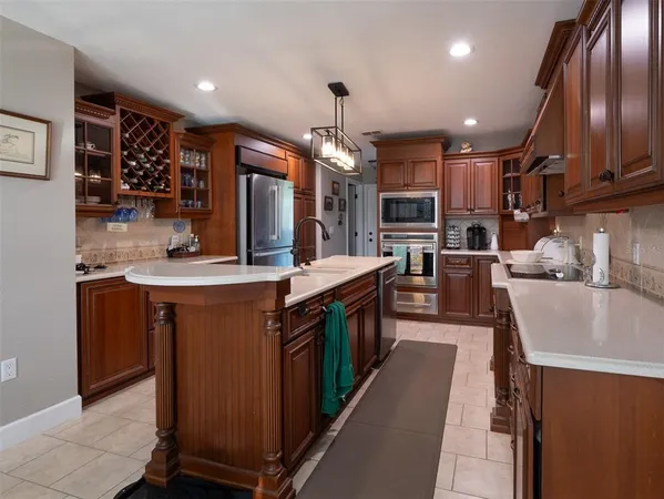 a kitchen with stainless steel appliances granite countertop a sink a stove and cabinets