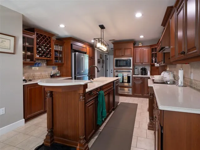 a kitchen with stainless steel appliances granite countertop a sink a stove and cabinets