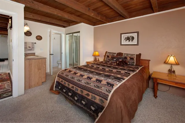 a bed sitting in a spacious bedroom next to a window