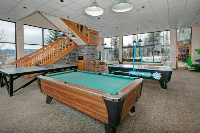 a room with pool table and windows