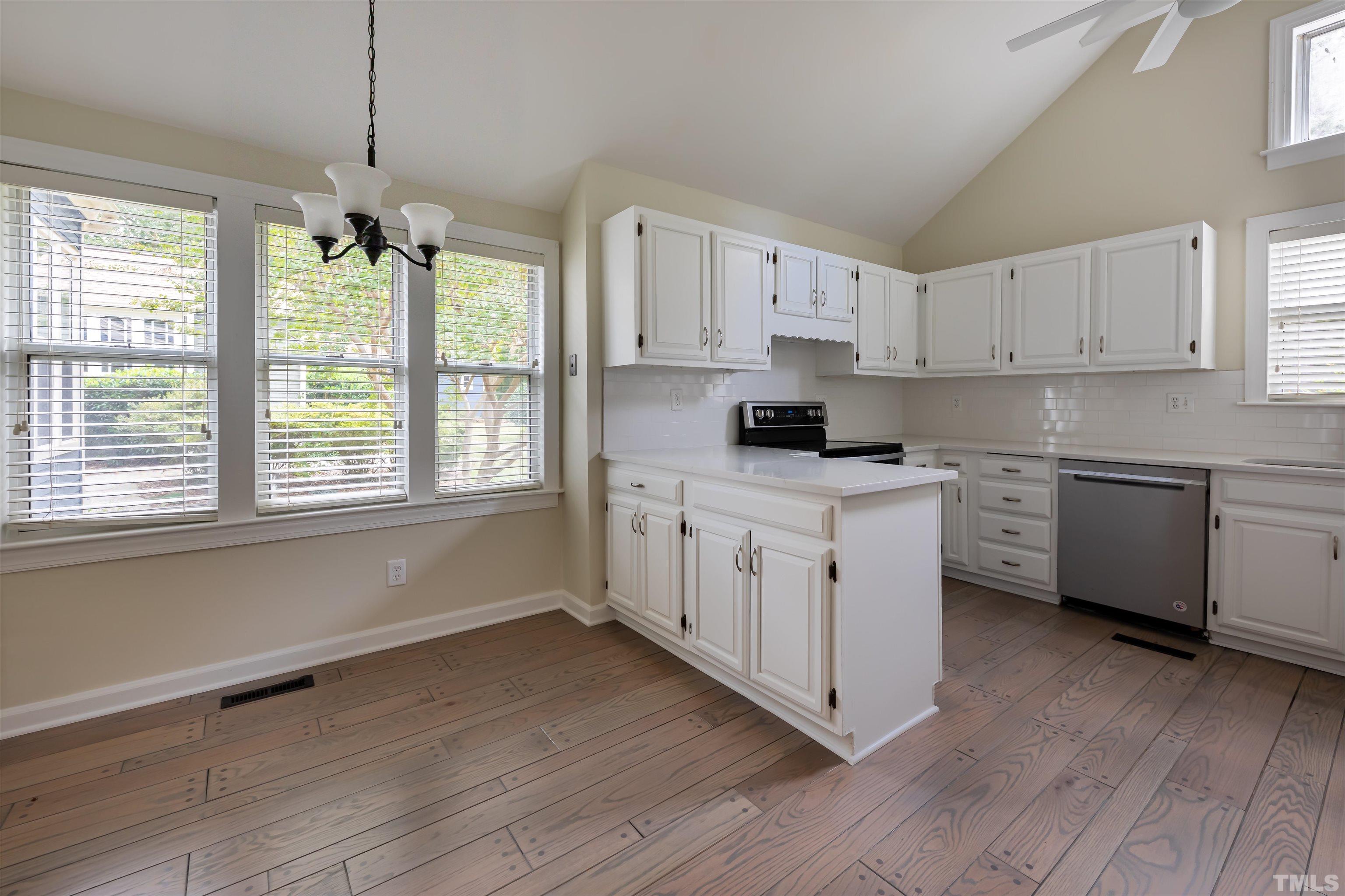 5810 Sentinel Drive Raleigh, NC 27609 - Photo 3 of 11 a kitchen with wooden floors and white cabinets