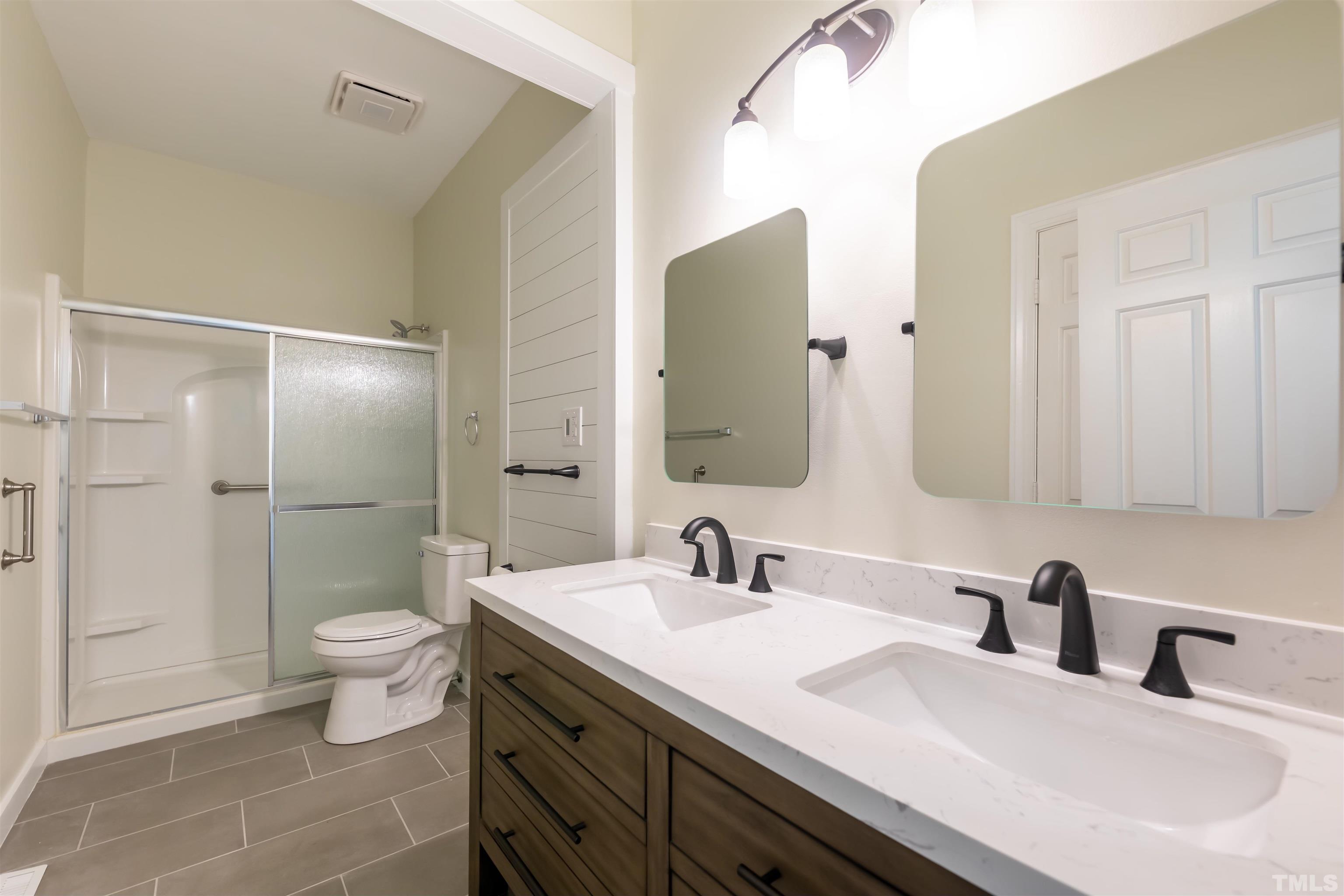 5810 Sentinel Drive Raleigh, NC 27609 - Photo 6 of 11 a bathroom with a double vanity sink toilet and shower