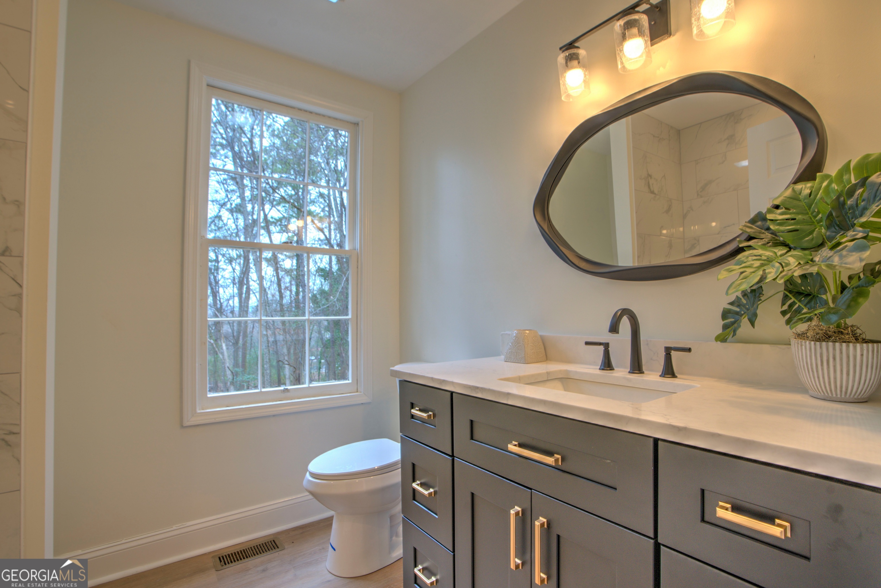 205 Mt Alto Road Southwest Rome, GA 30165 - Photo 22 of 36 a bathroom with a toilet a sink a mirror and a window