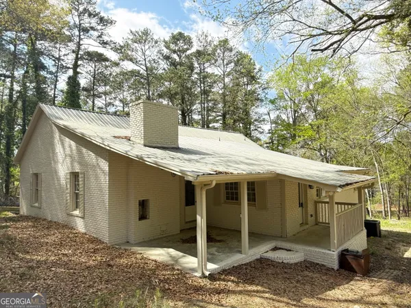 a view of a house with a yard and large tree