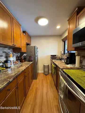 a kitchen with a sink appliances cabinets and a counter top space