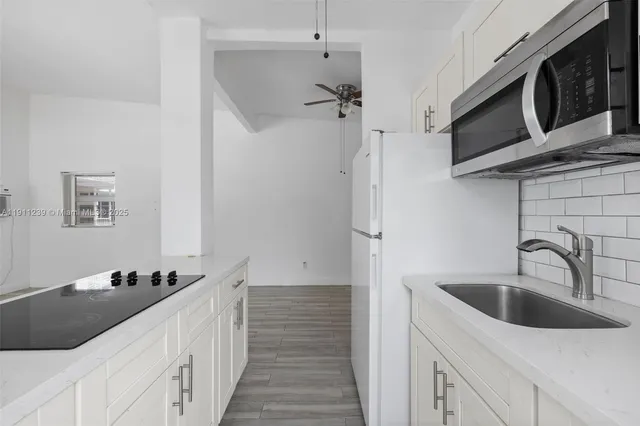 a kitchen with stainless steel appliances a sink a stove and a refrigerator