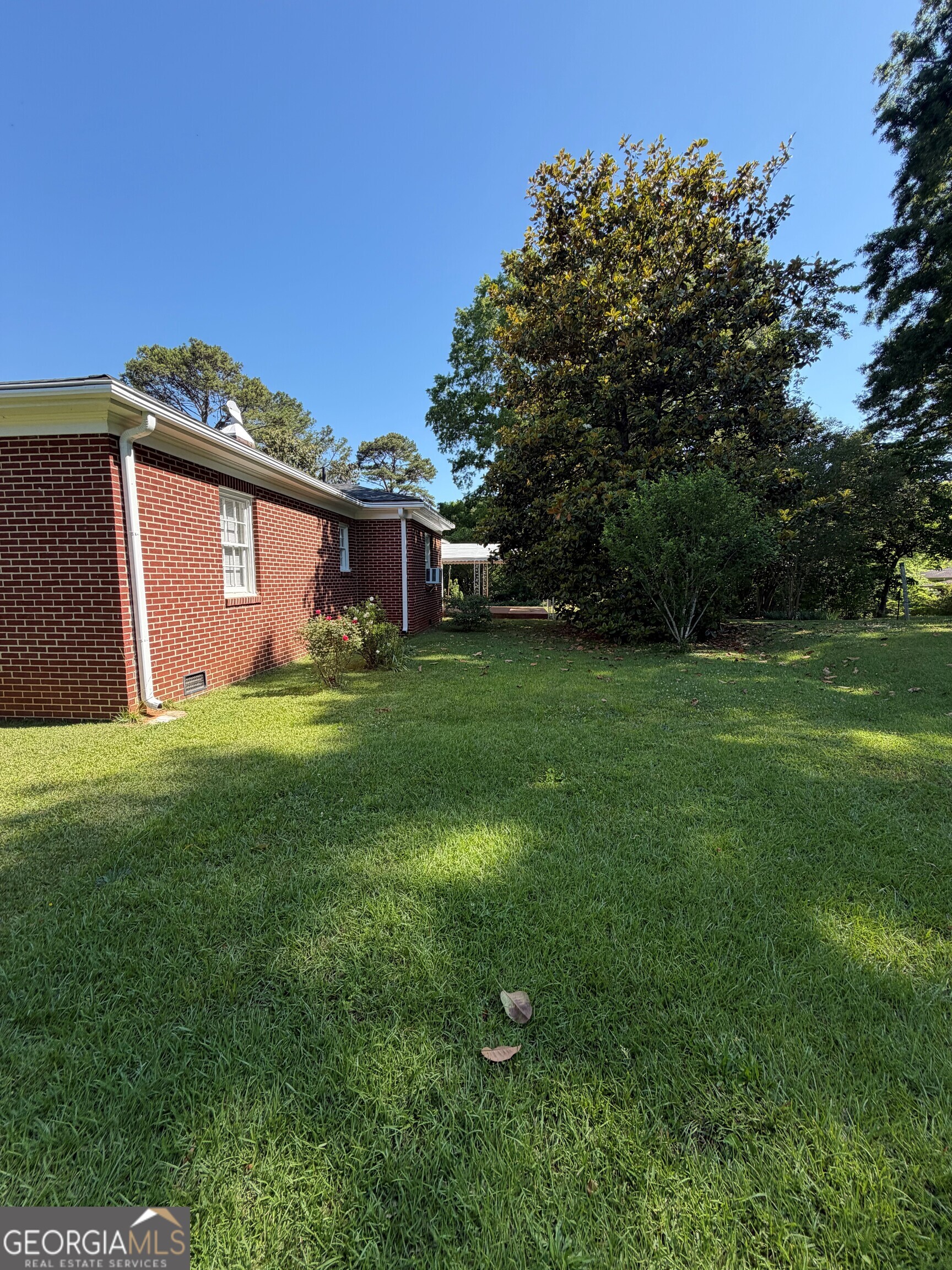 2619 Maple Road Southeast Rome, GA 30161 - Photo 16 of 31 a backyard of a house with potted plants and large tree