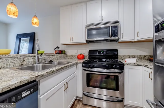 a kitchen with granite countertop a stove top oven microwave and cabinets