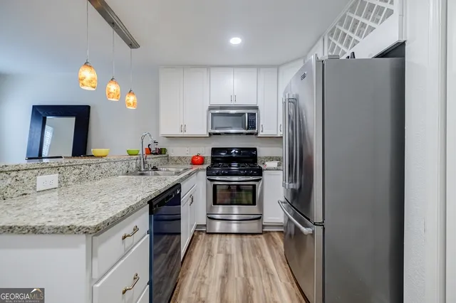 a kitchen with granite countertop a refrigerator and a sink