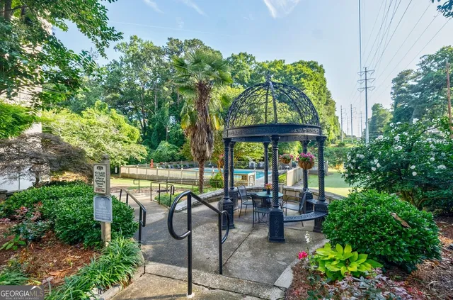 a view of a patio with table and chairs potted plants and floor to ceiling window