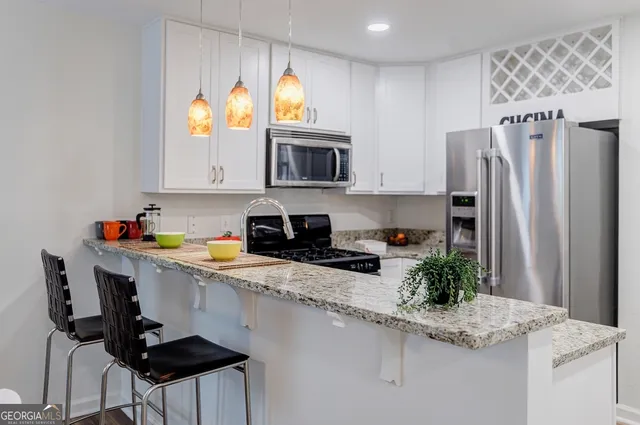 a kitchen with stainless steel appliances granite countertop a sink refrigerator and microwave