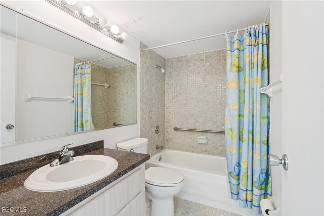 1006 Southeast 46th Street, Unit 1C Cape Coral, FL 33904 - Photo 15 of 26 a bathroom with a granite countertop sink toilet and shower