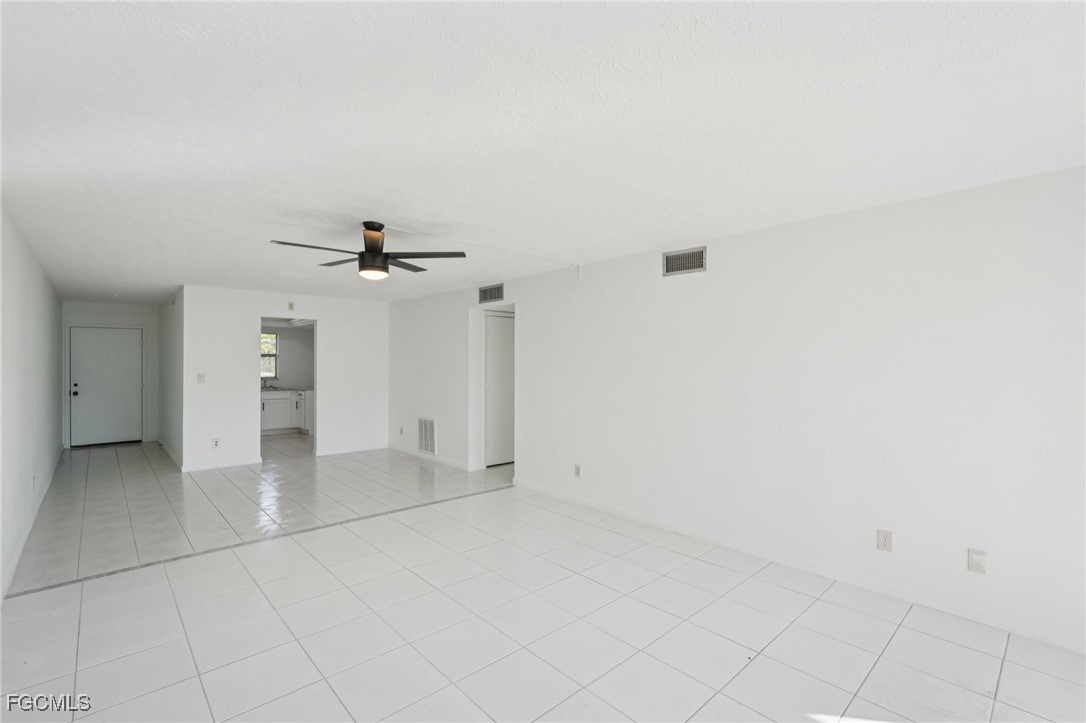 1006 Southeast 46th Street, Unit 1C Cape Coral, FL 33904 - Photo 2 of 26 an empty room with chandelier fan and windows