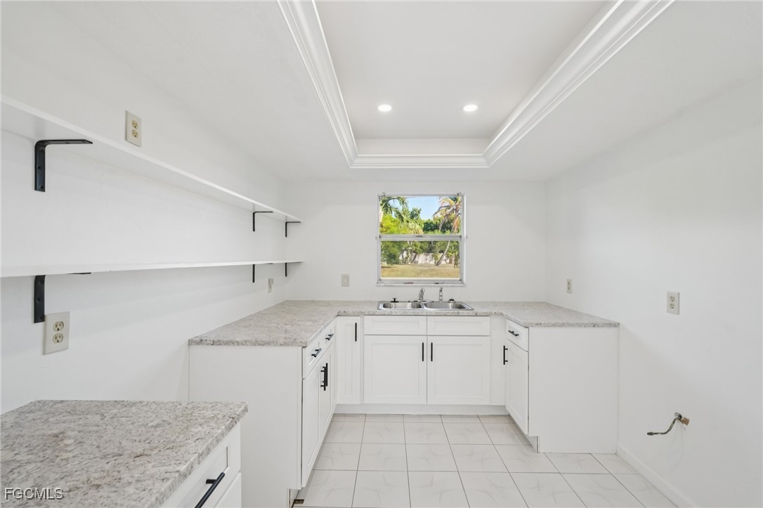 1006 Southeast 46th Street, Unit 1C Cape Coral, FL 33904 - Photo 6 of 26 a kitchen with a sink a stove cabinets and a window