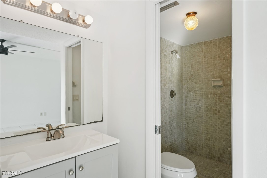 1006 Southeast 46th Street, Unit 1C Cape Coral, FL 33904 - Photo 10 of 26 a bathroom with a sink a toilet and shower