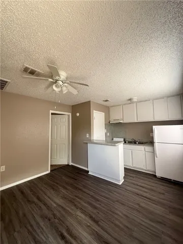 a kitchen with a wooden floor and white cabinets