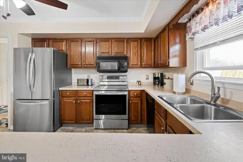 a kitchen with a refrigerator sink and wooden cabinets