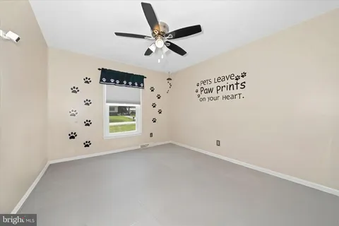 an empty room with window and ceiling fan