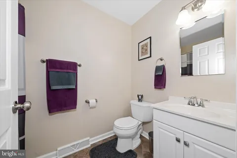 a bathroom with a toilet sink vanity and mirror