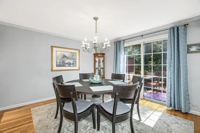 a dining room with furniture a chandelier and wooden floor