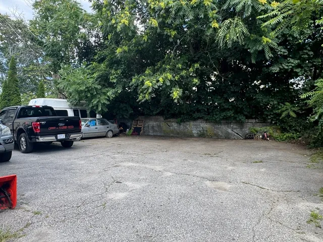 a view of house with a yard and floor to ceiling window and wooden fence