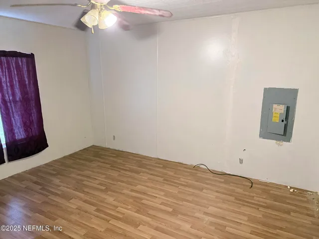 a view of empty room with wooden floor