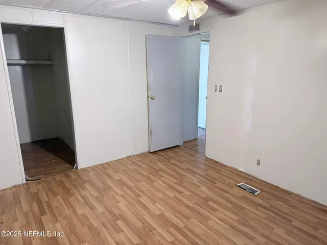 a view of empty room with wooden floor