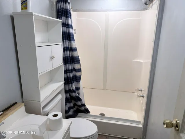 a bathroom with a toilet and a shower