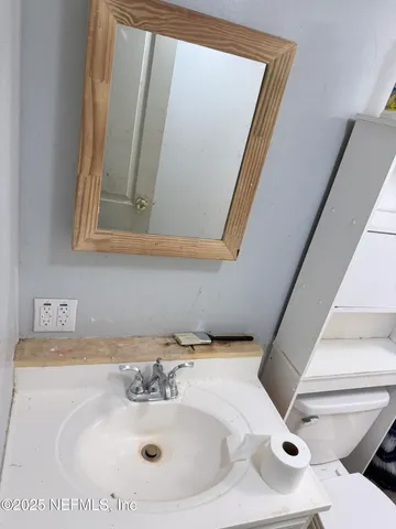 a bathroom with a sink and mirror with toilet