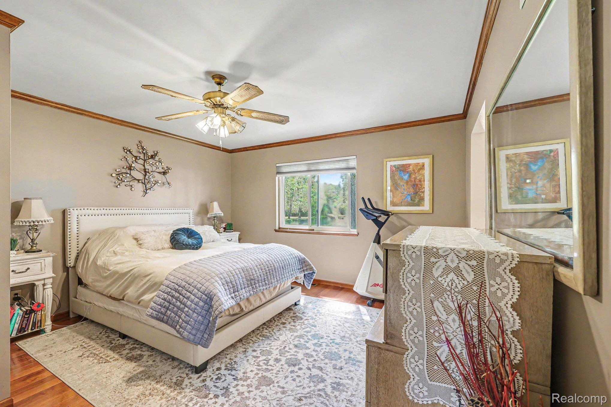 7020 Meldrum Road Fair Haven, MI 48023 - Photo 20 of 43 Spacious bedroom featuring wood-finish flooring, a ceiling fan with integrated lighting, and a large window