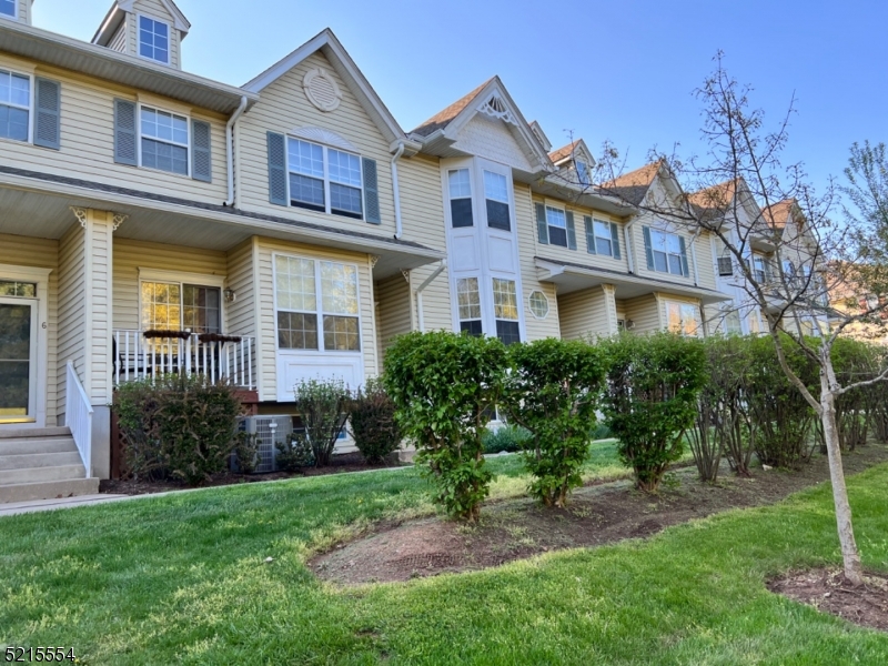 a view of a brick house with a yard and plants