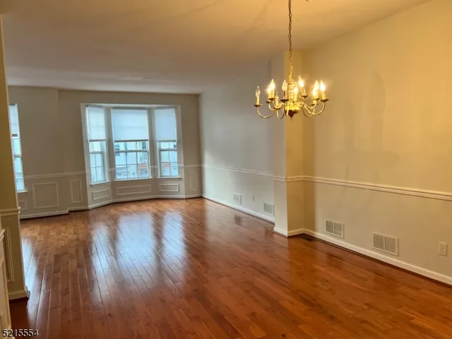 a view of a room with wooden floor and a window