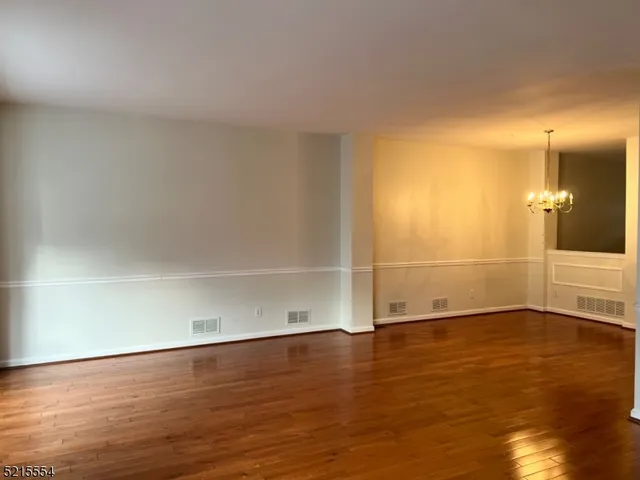 an empty room with wooden floor and white walls