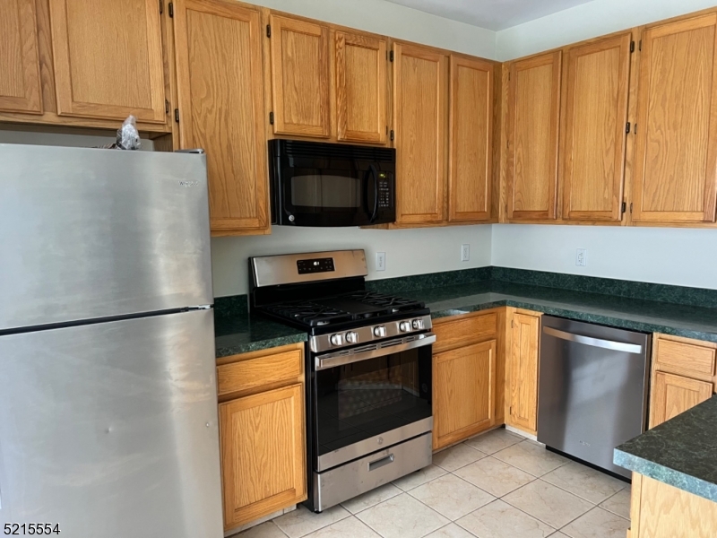 8 Worthington Terrace Flemington, NJ 08822 - Photo 7 of 18 a kitchen with stainless steel appliances granite countertop white cabinets a microwave a sink and a refrigerator