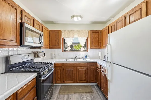a kitchen with a sink stove top oven and cabinets