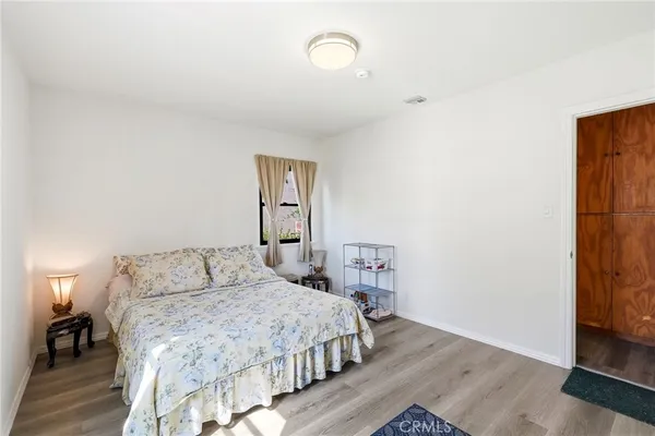 a bedroom with a bed and wooden floor