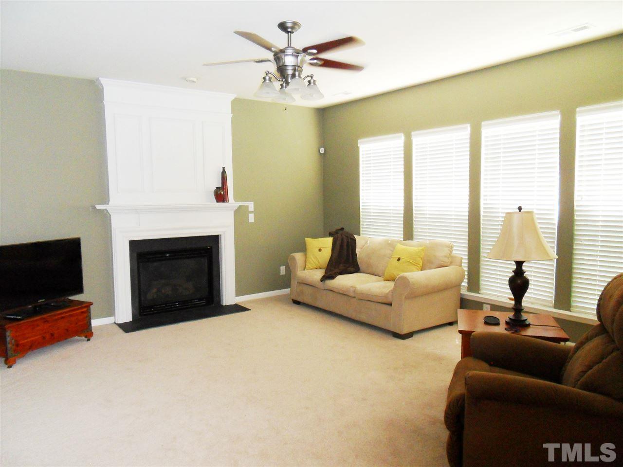 5327 Griffith Park Road Raleigh, NC 27613 - Photo 4 of 25 a living room with furniture a fireplace and a flat screen tv