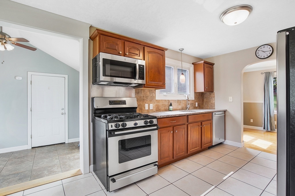 65 Bartels Street Springfield, MA 01128 - Photo 11 of 42 a kitchen with stainless steel appliances granite countertop a stove a sink and a microwave