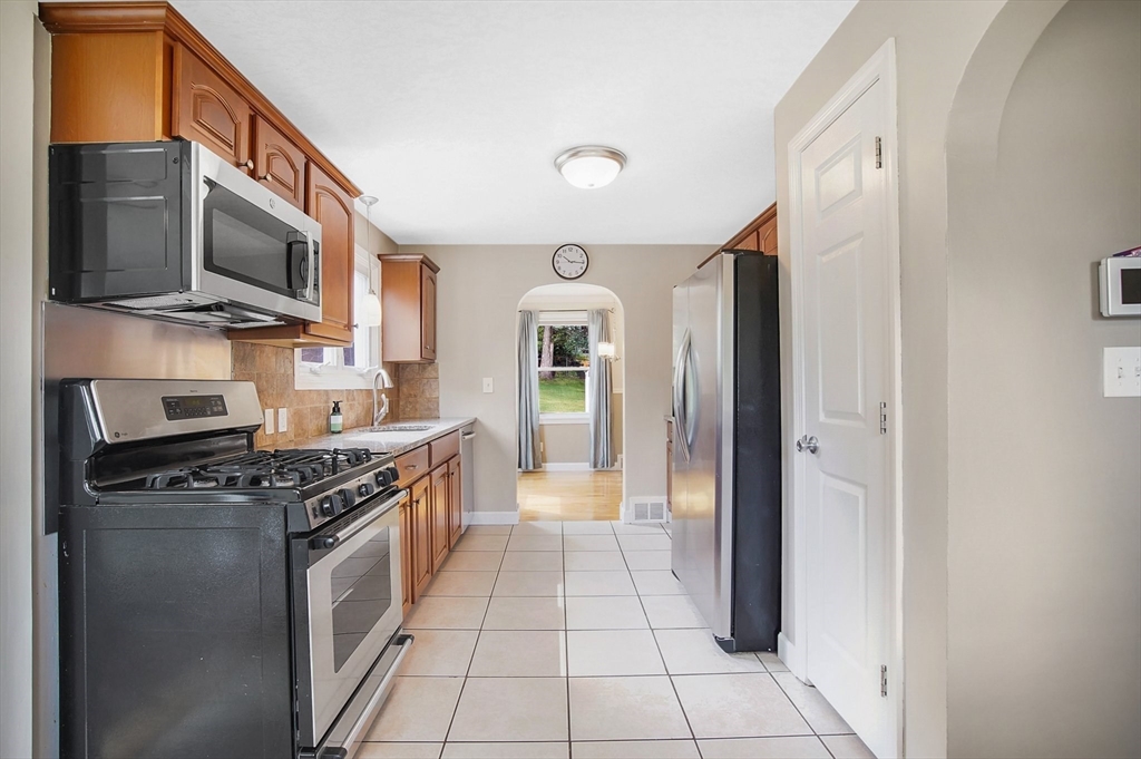 65 Bartels Street Springfield, MA 01128 - Photo 10 of 42 a kitchen with stainless steel appliances granite countertop a stove top oven a sink and a refrigerator
